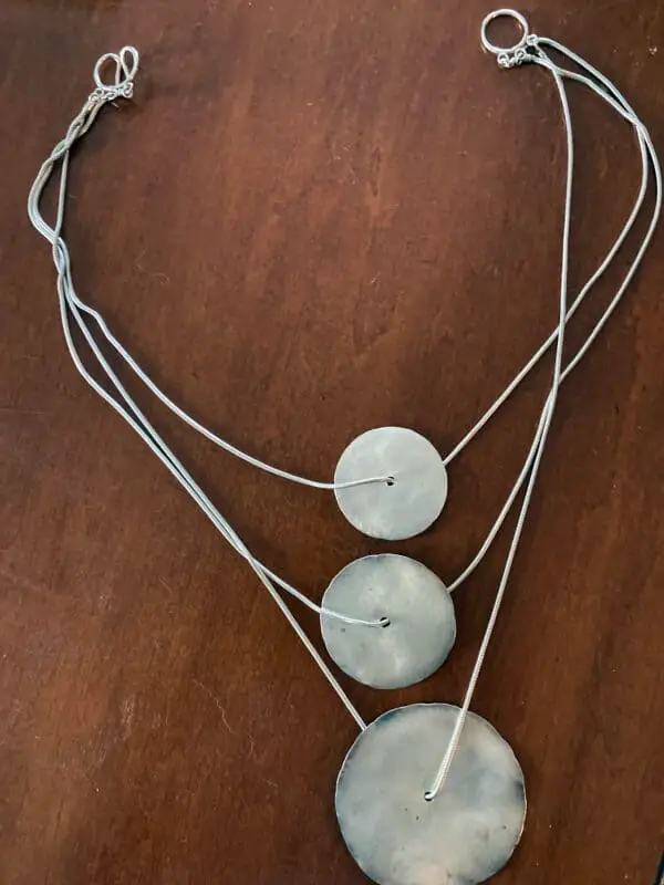 example of an artist necklace: silver chain with three discs (small, medium, and large)