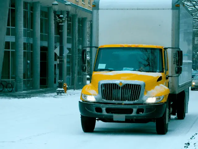 Moving Truck Driving on Snowy Road