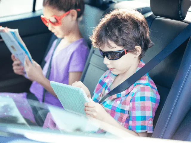 Kids in Car with Book and Ipad